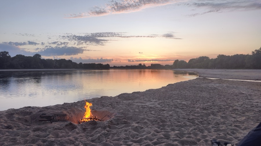 La Loire au coucher du soleil, un feu de bivouac allumé sur la grève.
